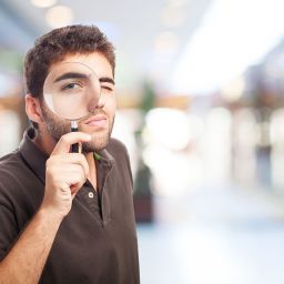 Estudiante analizando ofertas de trabajo con una lupa