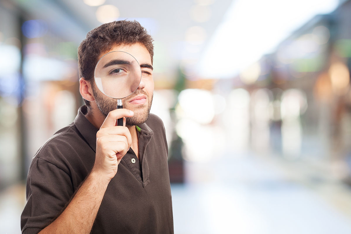 Estudiante analizando ofertas de trabajo con una lupa