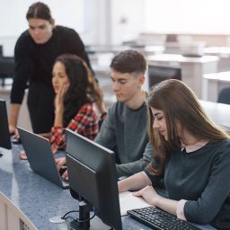 Estudiantes de informática trabajando con ordenadores en clase