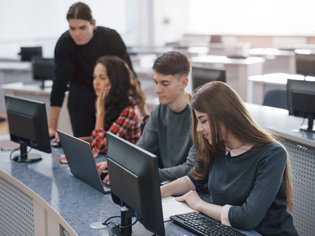 Estudiantes de informática trabajando con ordenadores en clase