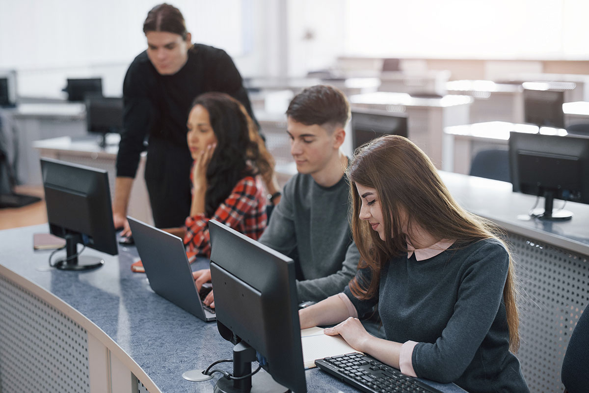 Estudiantes de informática trabajando con ordenadores en clase
